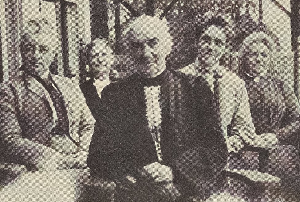 black and white photo of 5 women seated on a porch