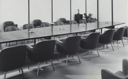 Long conference table with chairs and glass ashtrays