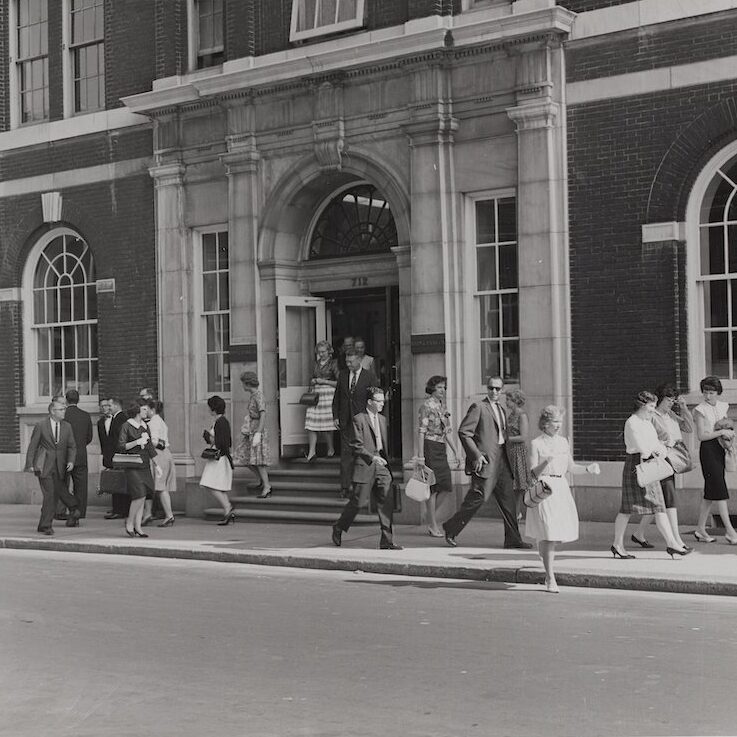 A black and white photo from 1965 of Rohm and Haas employees leaving the company's Philadelphia office