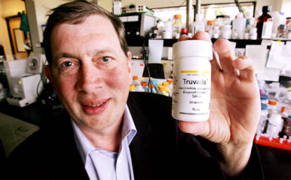 John C. Martin holds up a bottle of pills.
