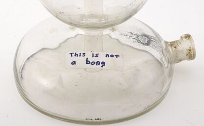 Glass vessel with handwritten label that reads "This is not a bong."