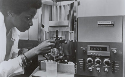 Women in lab coat using a spectrophotometer