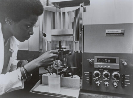 Women in lab coat using a spectrophotometer