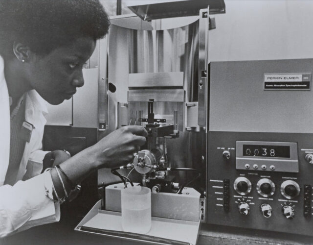 Women in lab coat using a spectrophotometer
