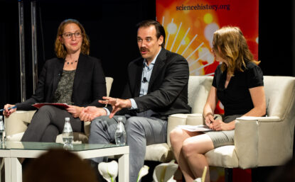4 people seated on a stage having a discussion