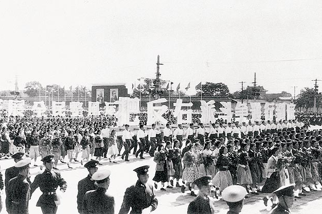 Soldiers and civilians marching in a rows