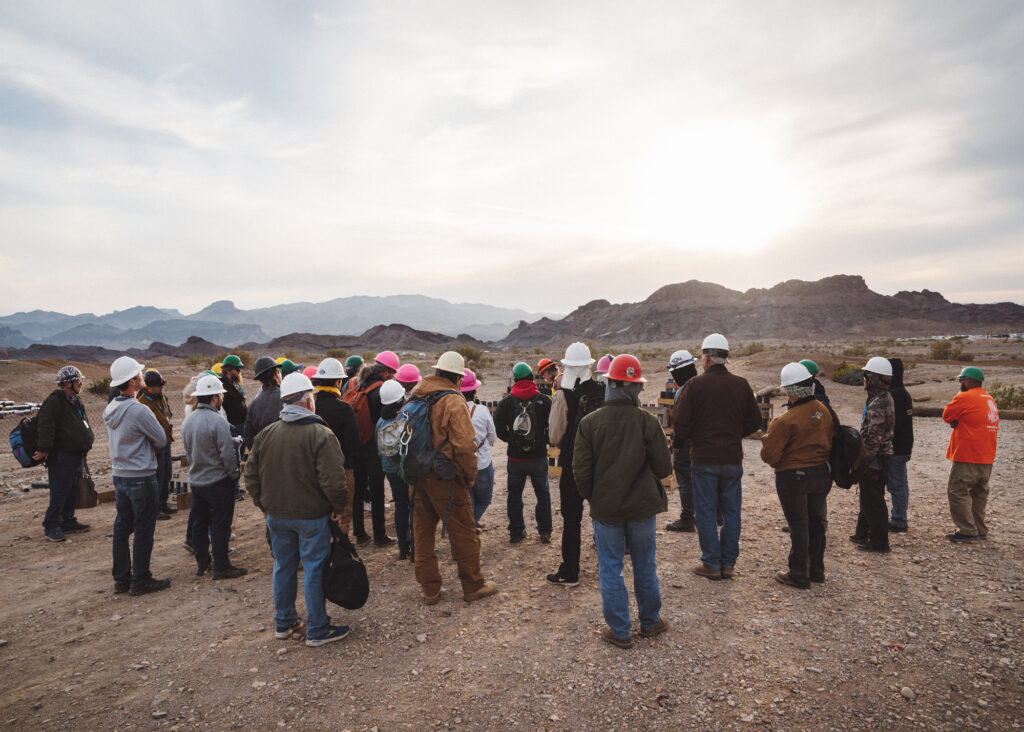 Large group of people in safety equipment gathered in the desert