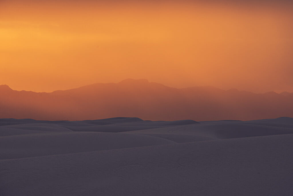 Landscape photo of orange sky over sand dunes