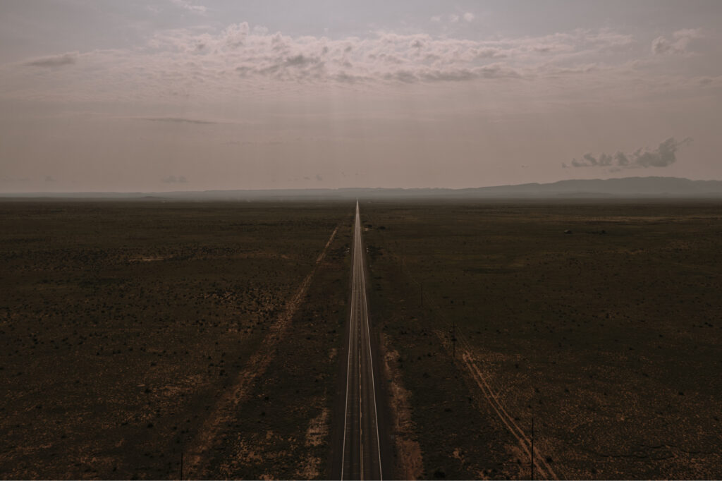 Wide landscape photo of a straight empty highway in the desert 