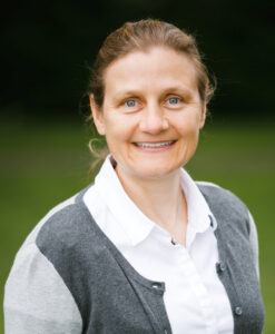 Tanja Gruber outdoors, smiling, gray jacket over white shirt