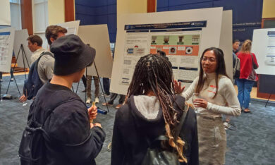 Scientist discussing her poster with visitors