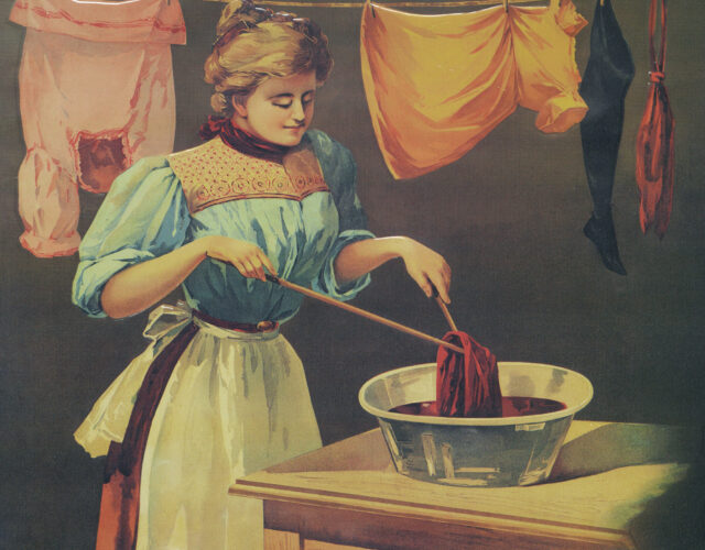 woman in apron dyeing cloth in a basin