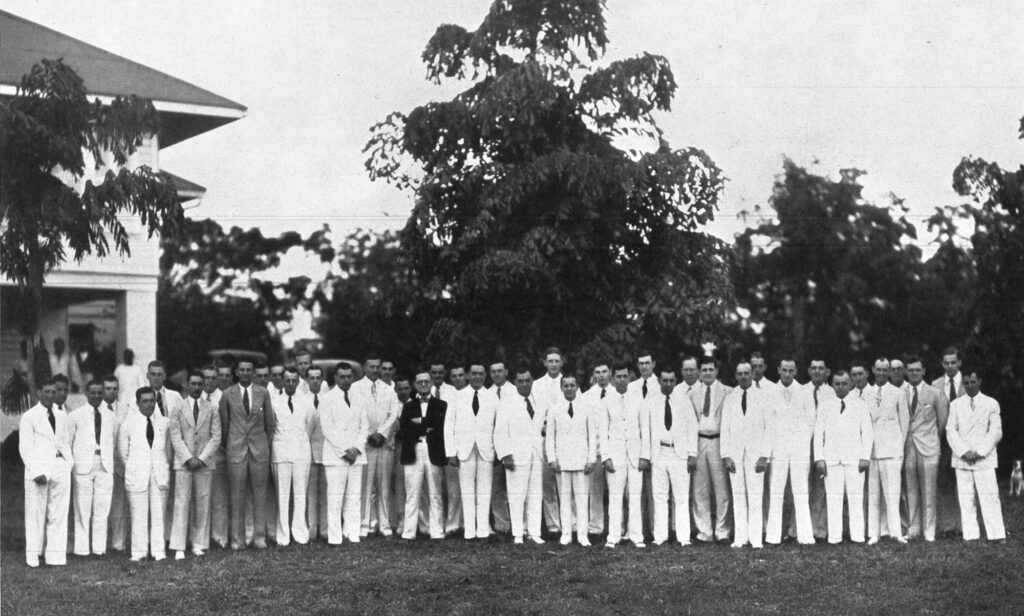 Large group of men standing outdoors in white suits