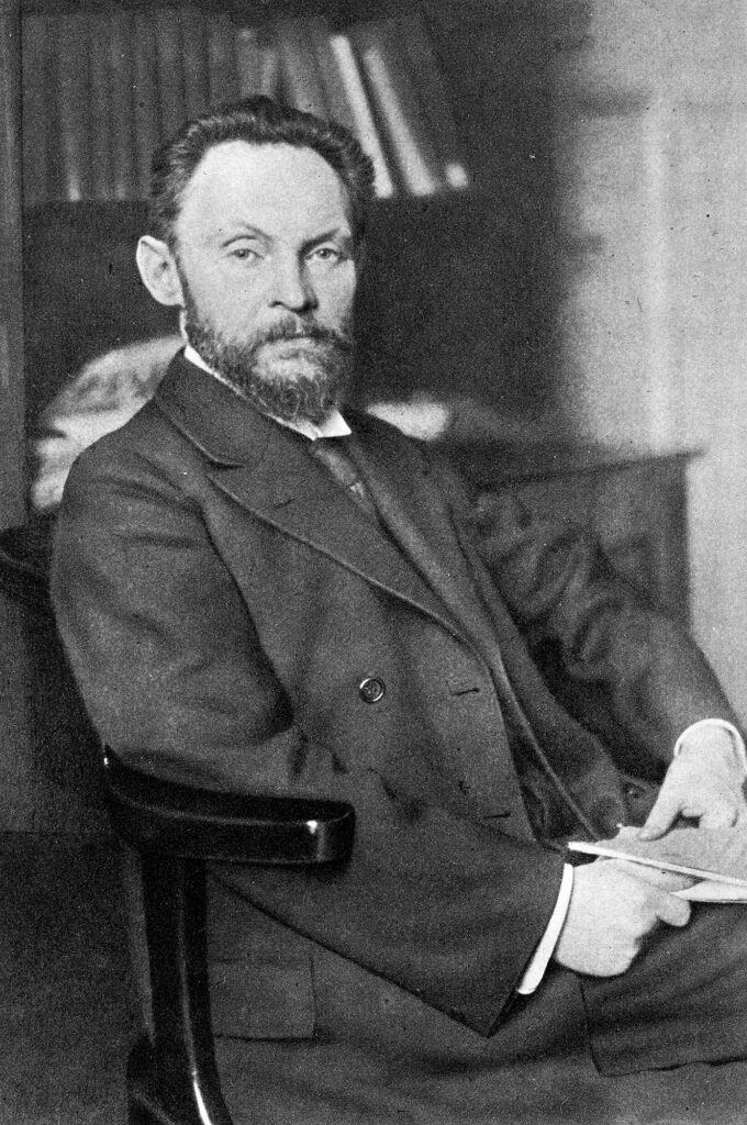 Photo portrait of a seated bearded man in a suit