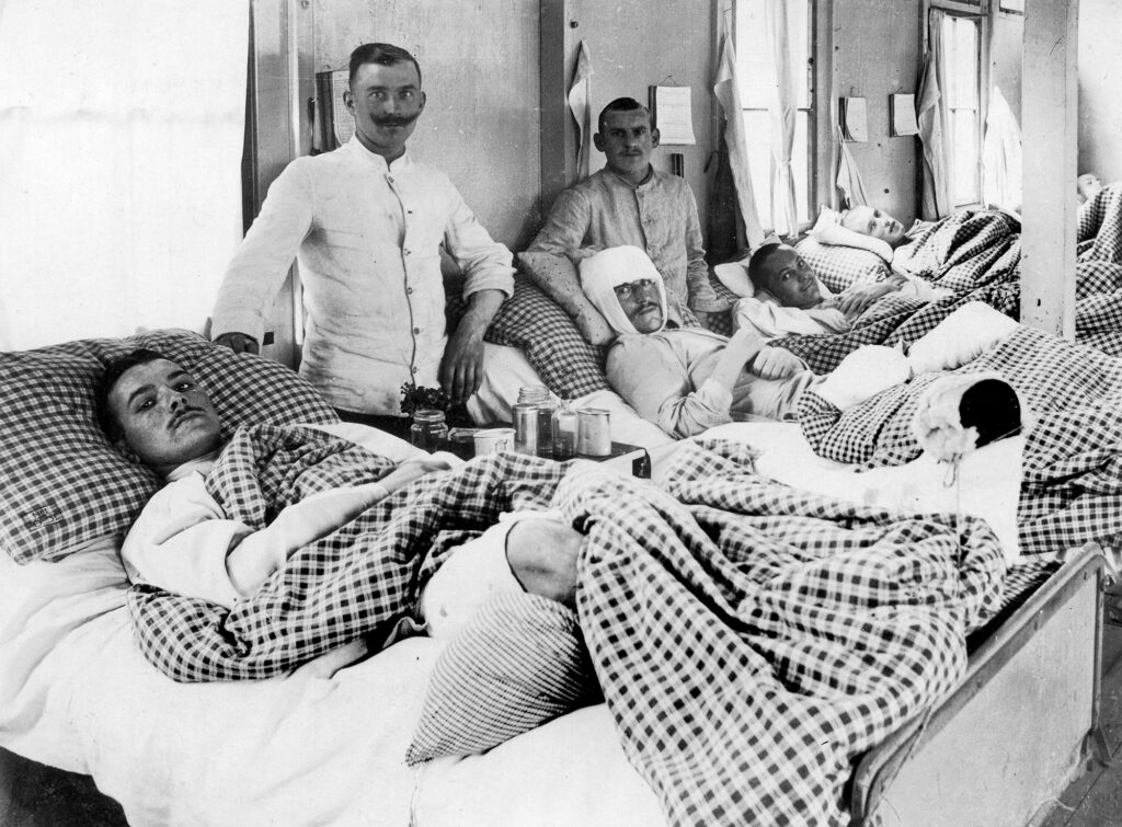 Inured young men with wounds wrapped lying in hospital beds
