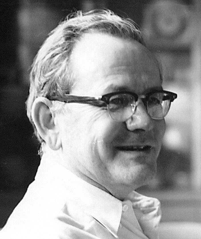 Black and white headshot of middle-age man wearing glasses