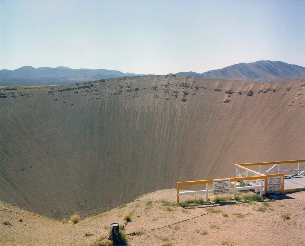 Color photo of a large, sandy blast crater