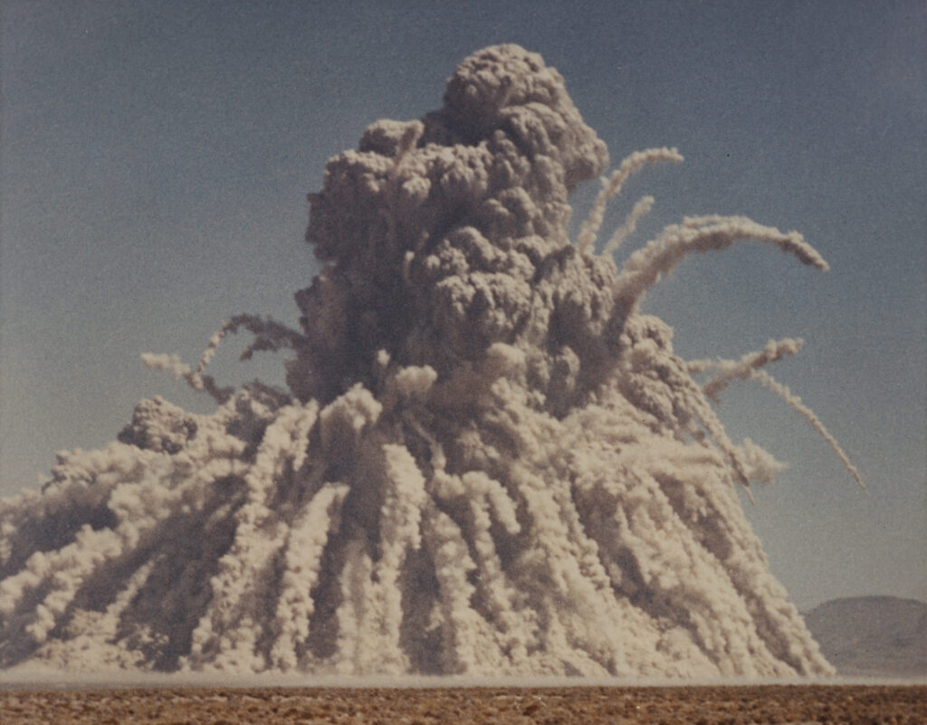 Color photo of a large explosion in the desert