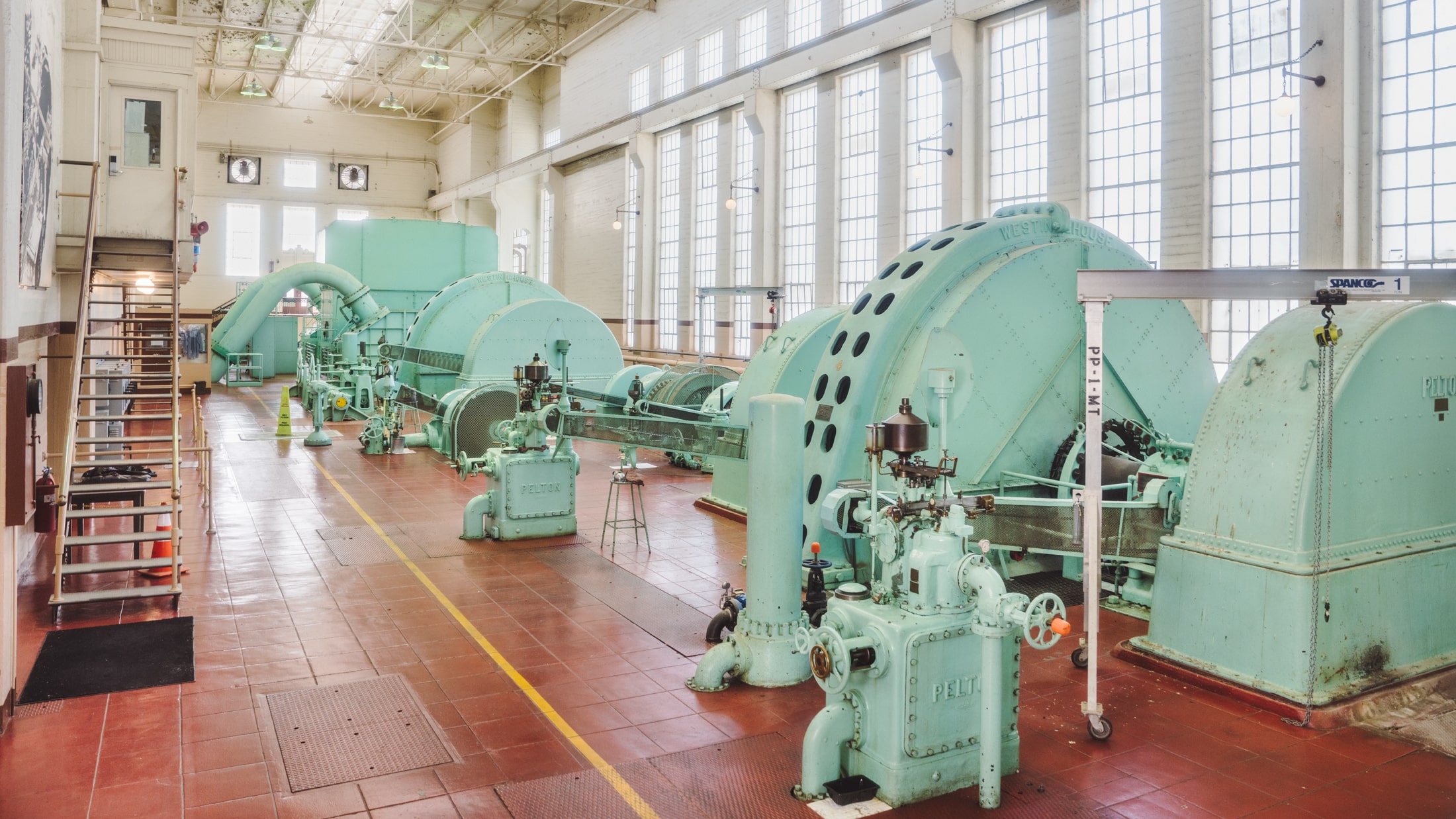 Industrial interior with red tile flooring and large machinery painted teal