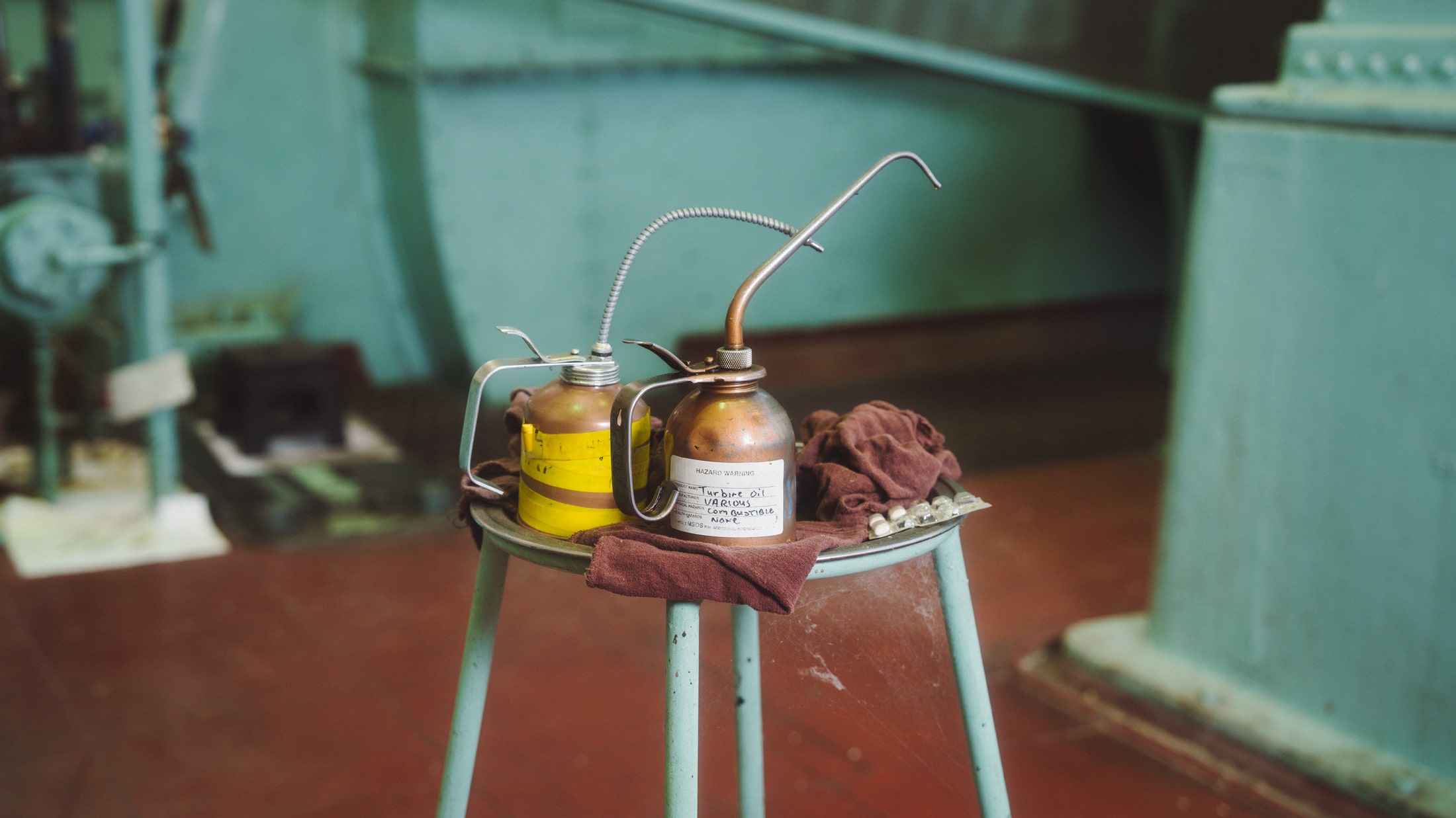 Close up of oil cans on a metal stool