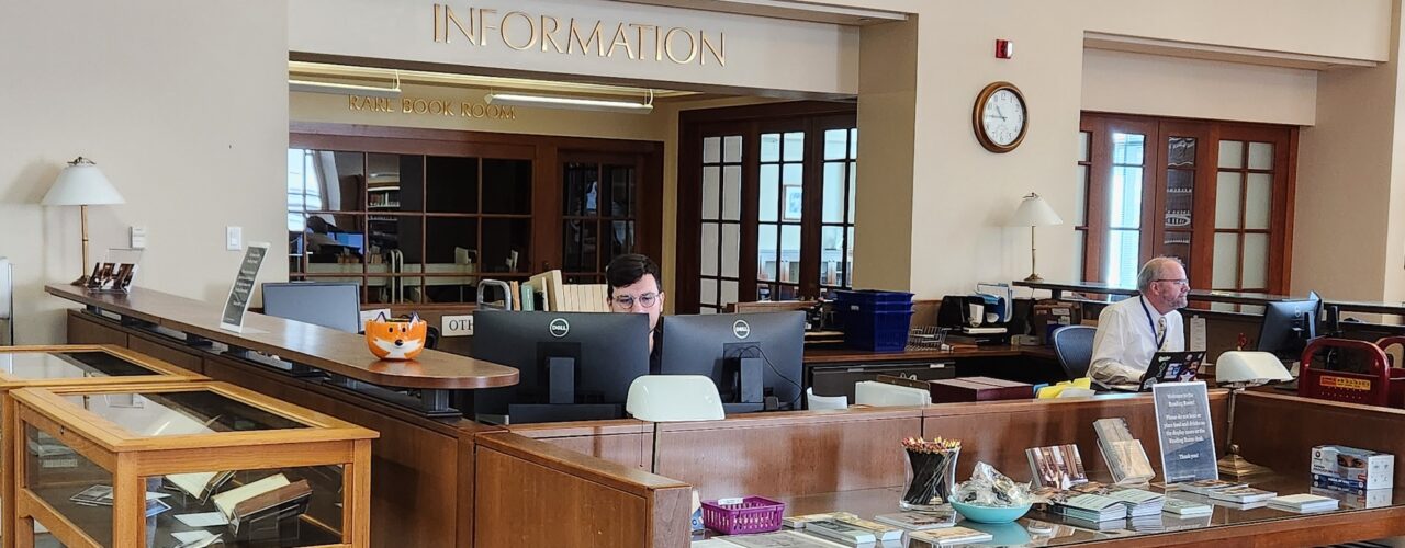 2 people sitting at a library information desk