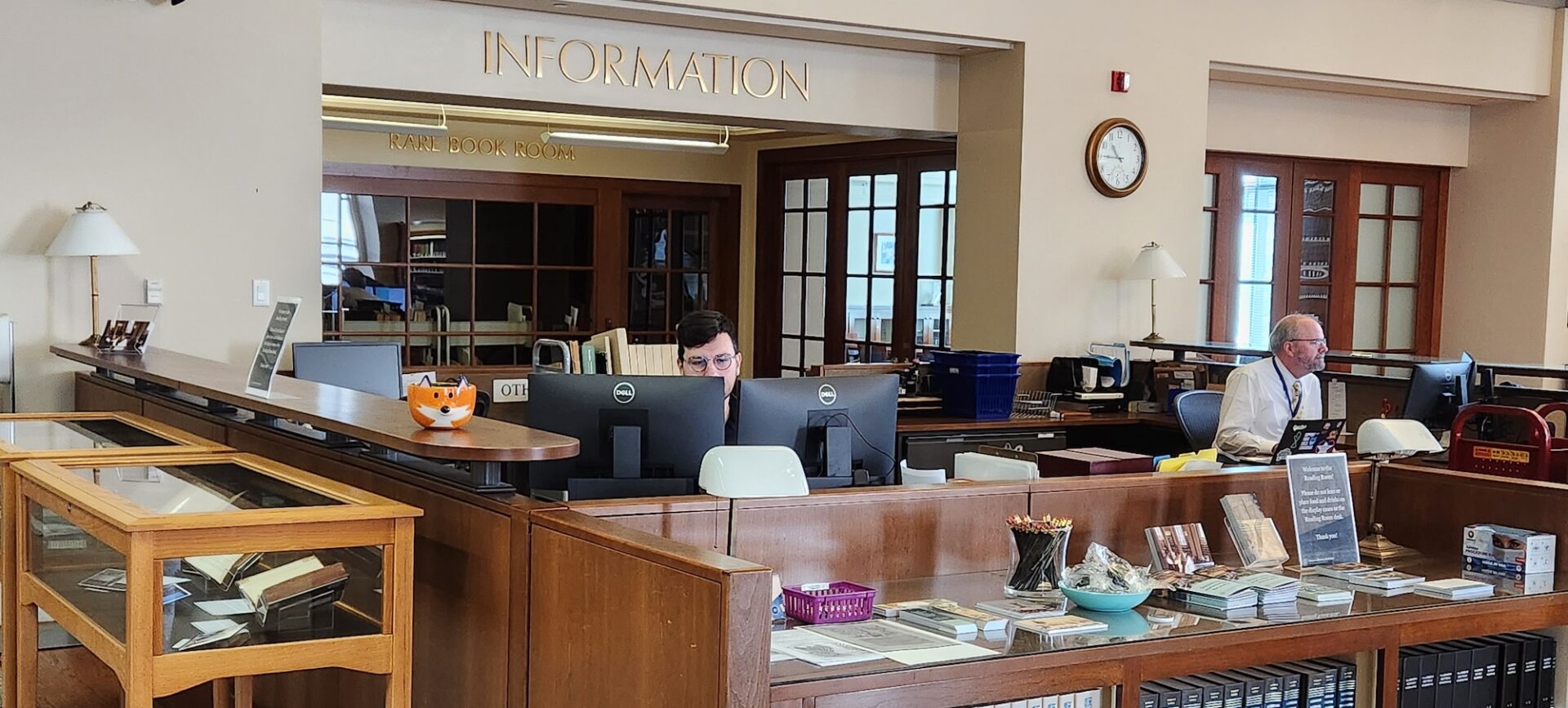 2 people sitting at a library information desk