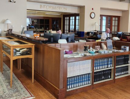 2 people sitting at a library information desk