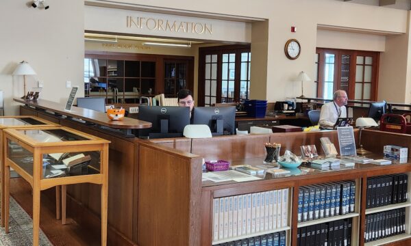 2 people sitting at a library information desk