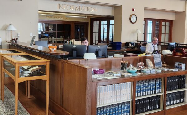 2 people sitting at a library information desk