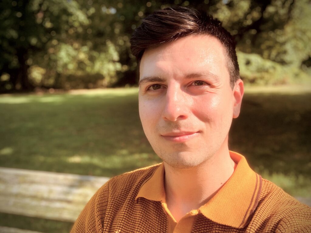 color photo of a man wearing an orange shirt