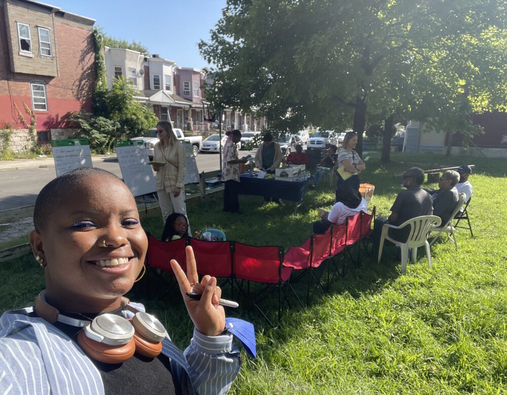 Ahilah Chatman in a park making a V sign, in front of Science Shop group