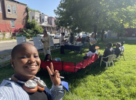 Ahilah Chatman in a park making a V sign, in front of Science Shop group