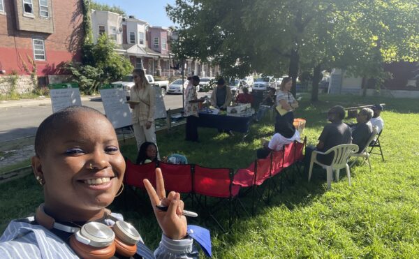 Ahilah Chatman in a park making a V sign, in front of Science Shop group