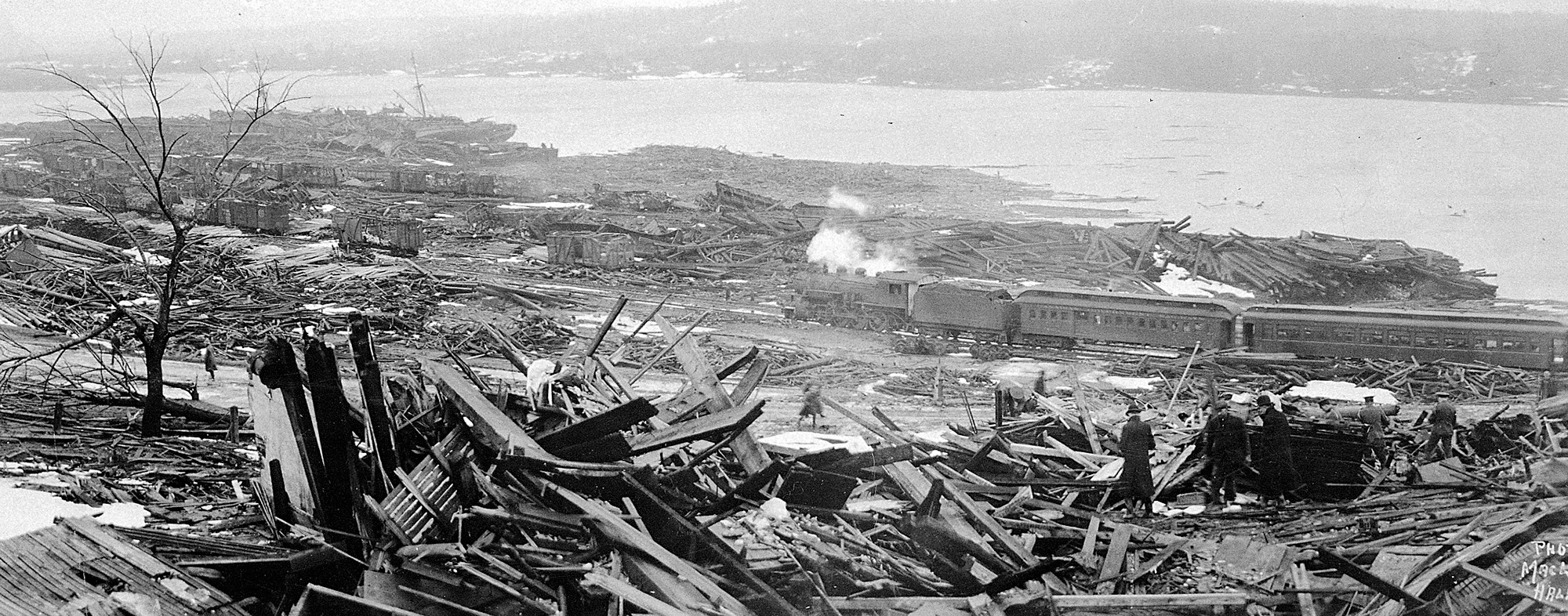 Old panoramic photo showing destroyed buildings near a waterway