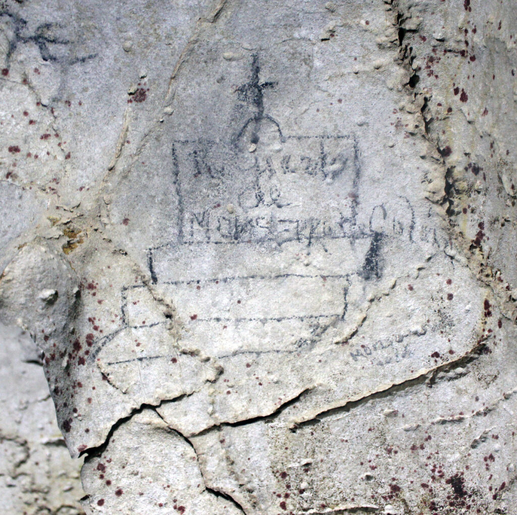 Photograph of a pencil or charcoal drawing of a stepped tomb with cursive writing