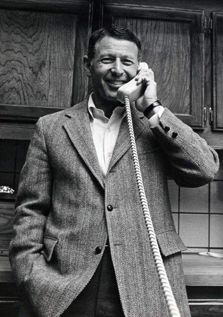 Smiling man in a kitchen on the phone