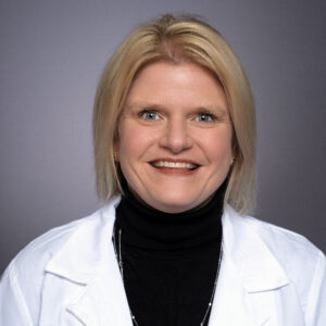 Jennifer Domm, studio portrait, smiling, wearing lab coat