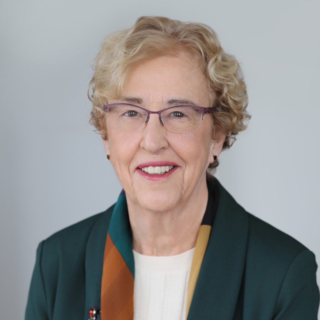 studio portrait of Lita Nelsen in glasses, striped silk scarf, and green jacket